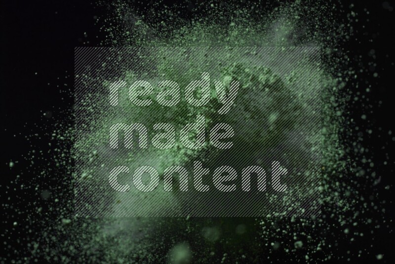 Green powder explosion on black background