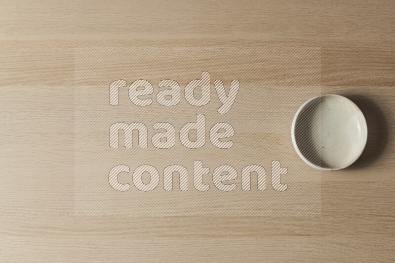 A white pottery bowl on light wooden background