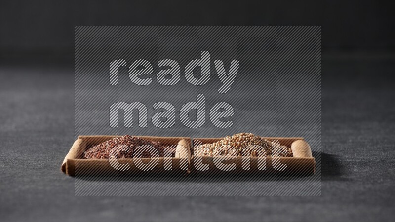 مربعان من أعواد القرفة ممتلئان بحبوب الخردل وحب الرشاد علي خلفية سوداء