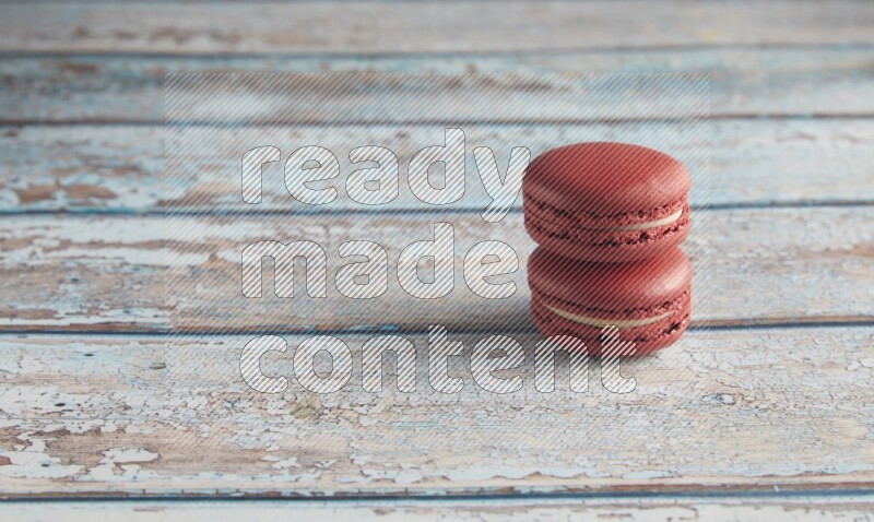 45º Shot of two Red Velvet macarons on light blue wooden background