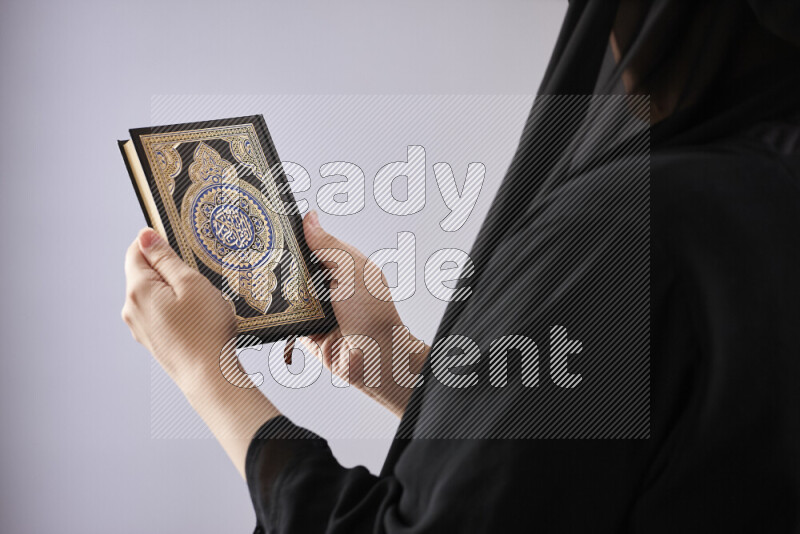 امرأة تحمل بيديها مصحف القرآن في أوضاع متعددة