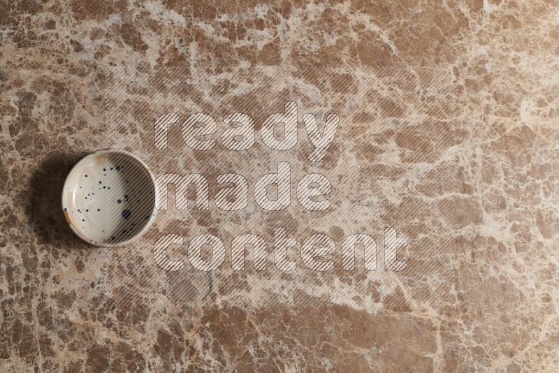 وعاء فخاري متعدد الألوان على خلفية من الرخام البيج