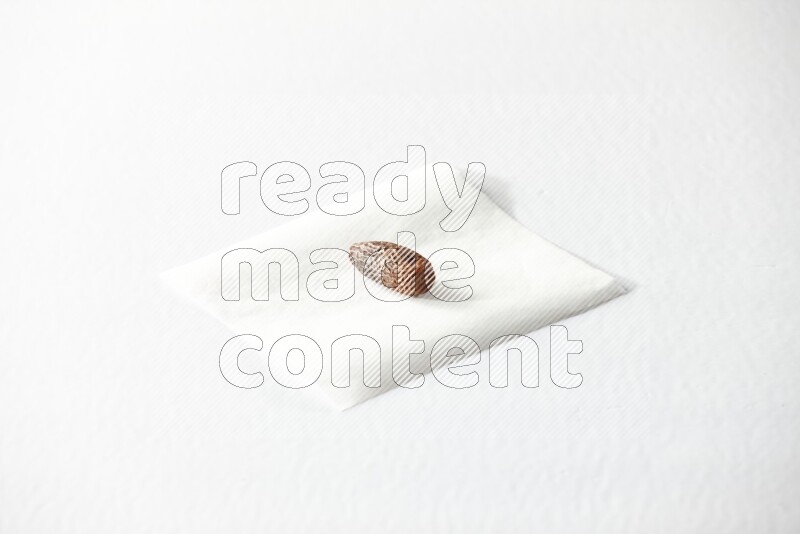 A dried date on a piece of paper on a white background in different angles