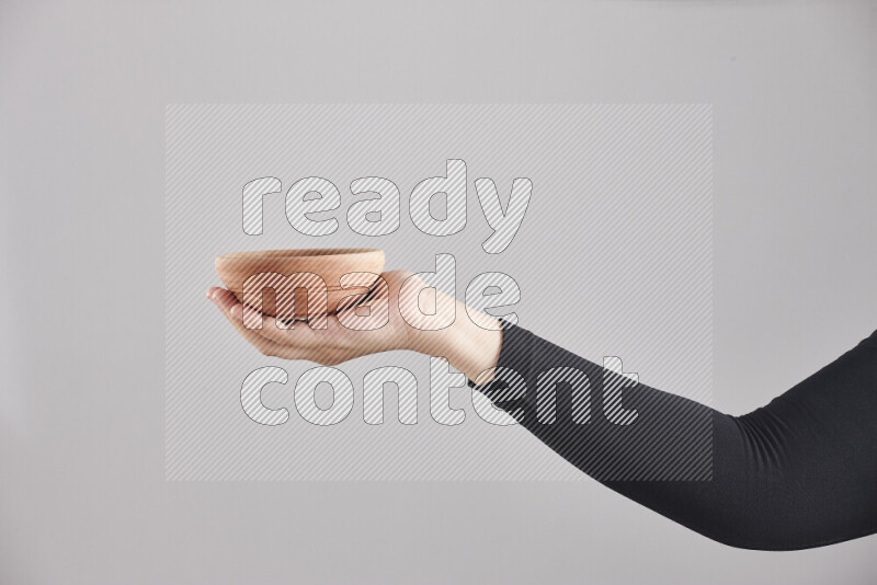 امرأة ترتدي عباءة سوداء تحمل أدوات خشبية مختلفة في أوضاع متعددة