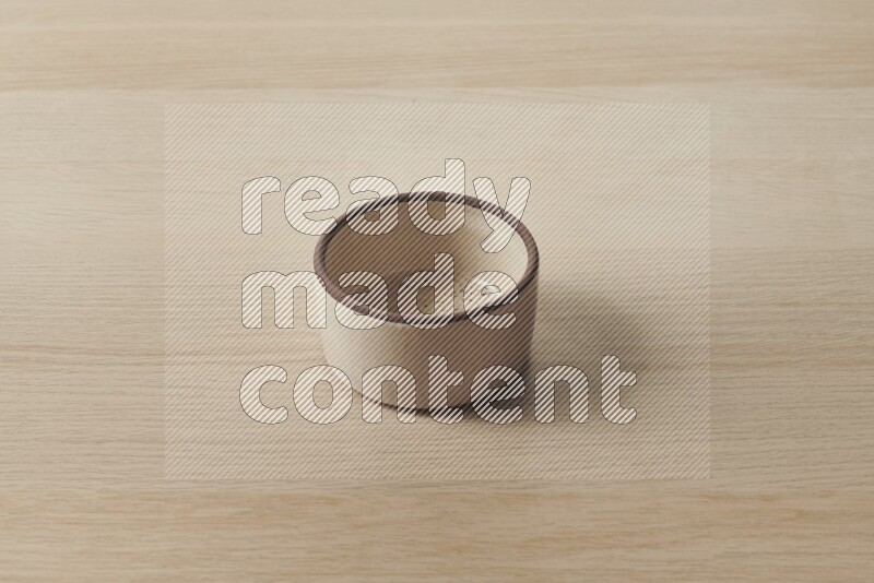 A beige pottery oven bowl on light wooden background