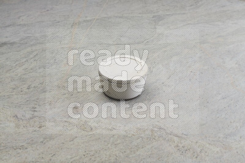 A white pottery bowl on grey marble background