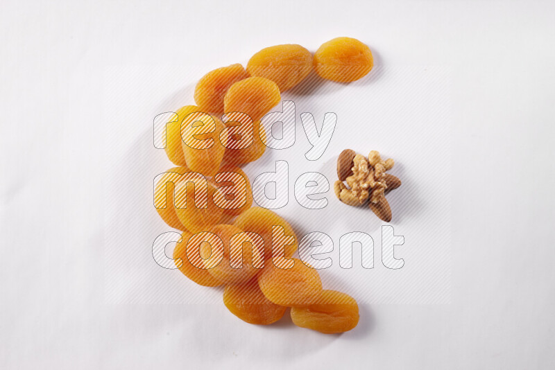 Dried apricots in a crescent shape on white background