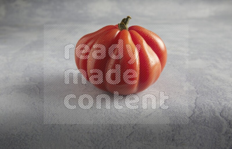 45 degree single heirloom tomato on a light blue textured background