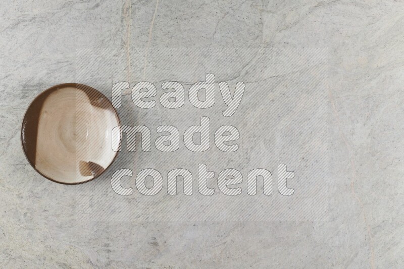A multicolored pottery plate on grey marble background