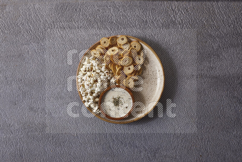 Assorted snacks in pottery bowls on grey background