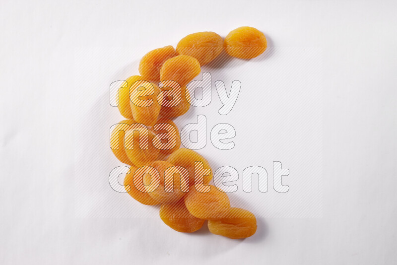 Dried apricots in a crescent shape on white background