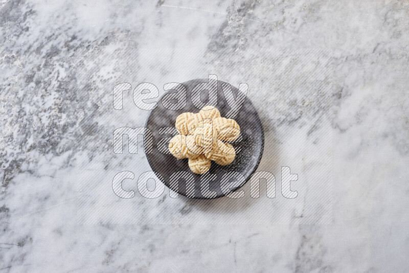 Kahk in black pottery plate on grey marble background