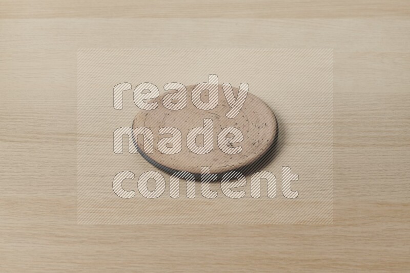 A pottery coaster on light wooden background