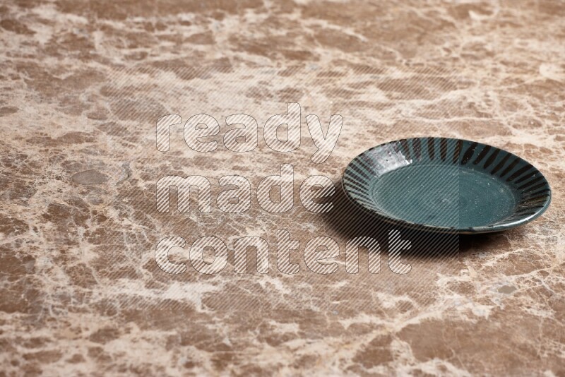 A multicolored pottery plate on beige marble background