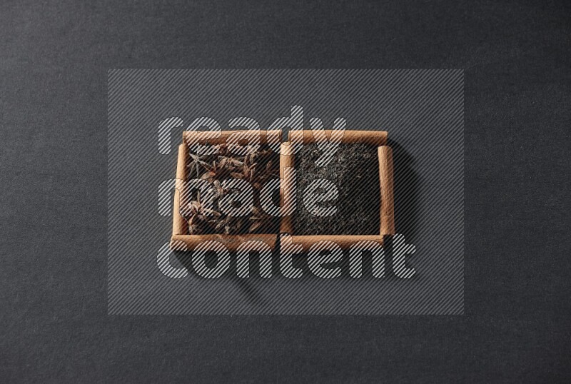 2 squares of cinnamon sticks full of star anise and black tea on black flooring