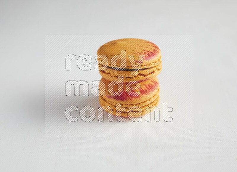 45º Shot of two orange Exotic macarons on white background