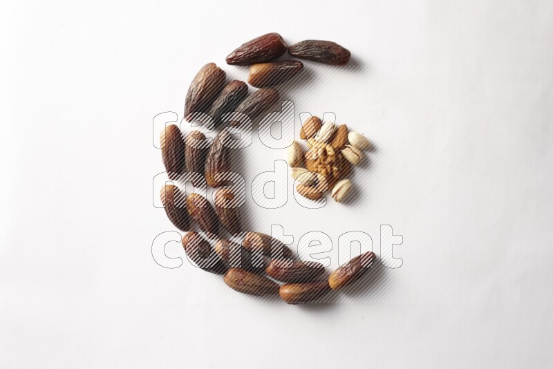 Dates in a crescent shape with nuts on white background