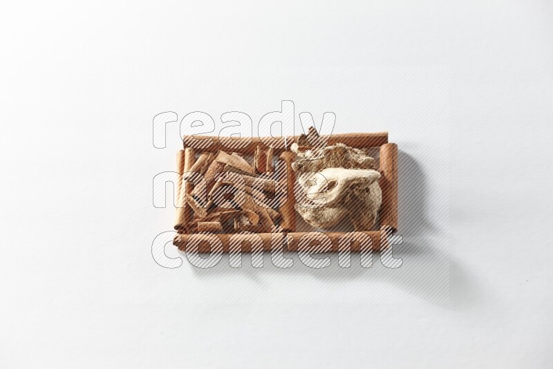 2 squares of cinnamon sticks full of cinnamon and dried ginger on white flooring