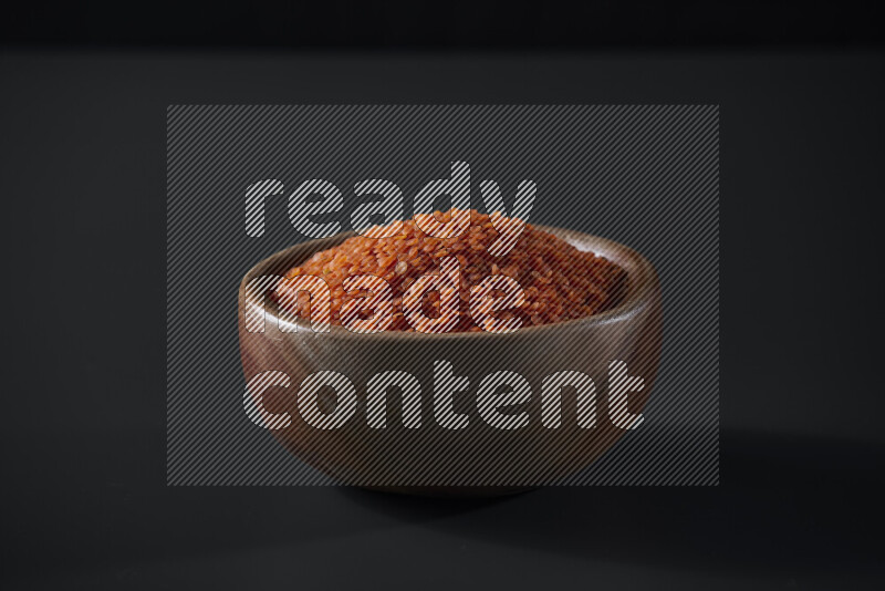 Lentils in a wooden bowl on grey background