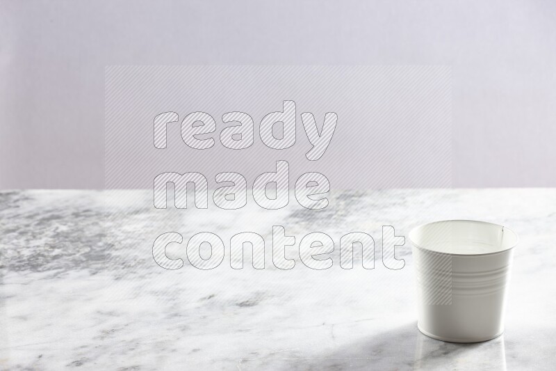 An empty white plant pot on grey marble background