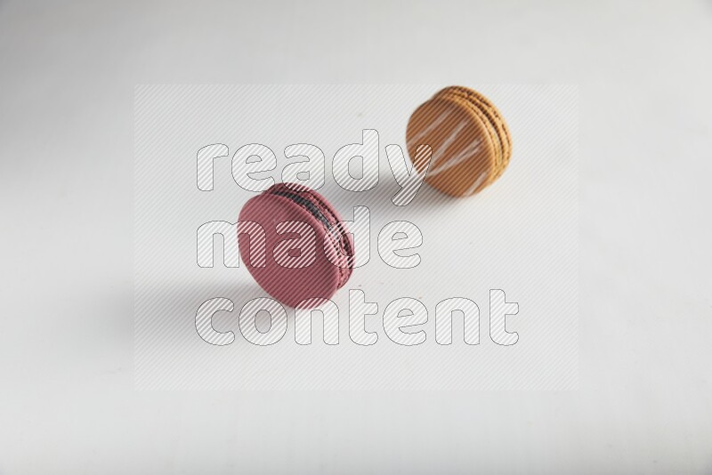 45º Shot of of two assorted Brown Irish Cream, and Red Cherry macarons on white background