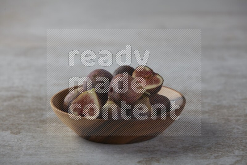 Fresh figs in a bowl on textured grey background