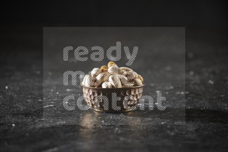 مكسرات في وعاء معدني علي خلفية سوداء