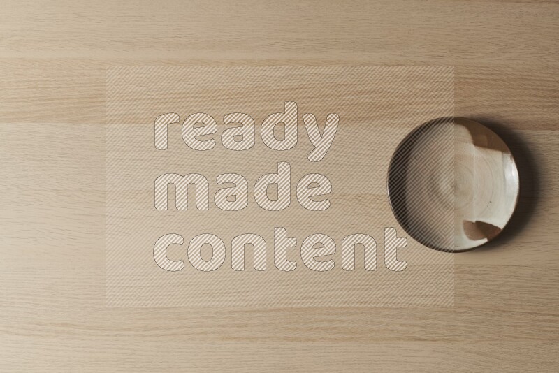 صحن فخاري متعدد الألوان على خلفية خشبية فاتحة