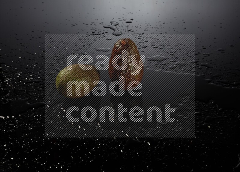 A whole avocado on black background with water drops.