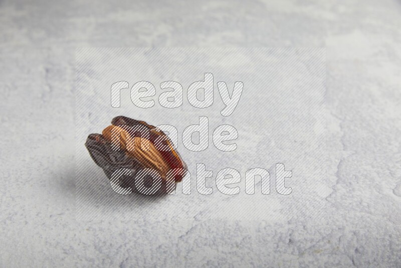 almond stuffed madjoul date on a light grey background