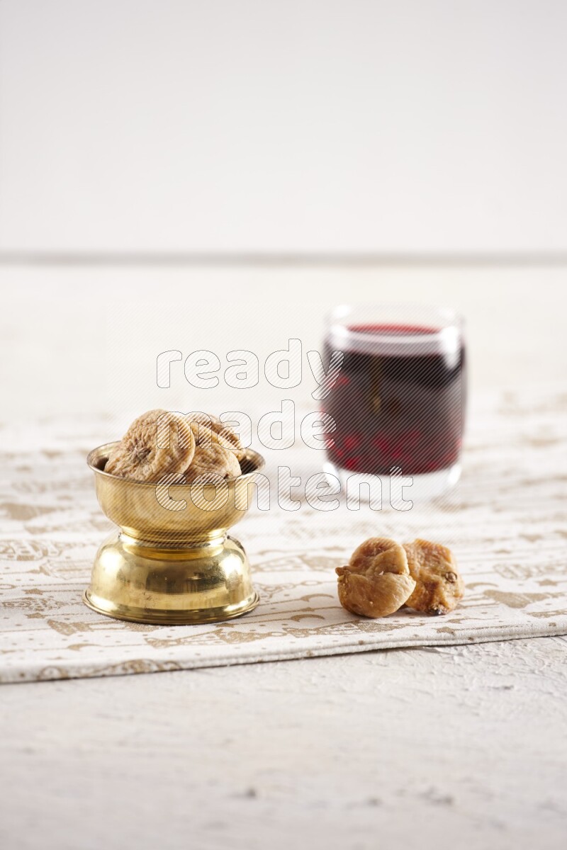 Dried fruits in a metal bowl with hibiscus in a light setup