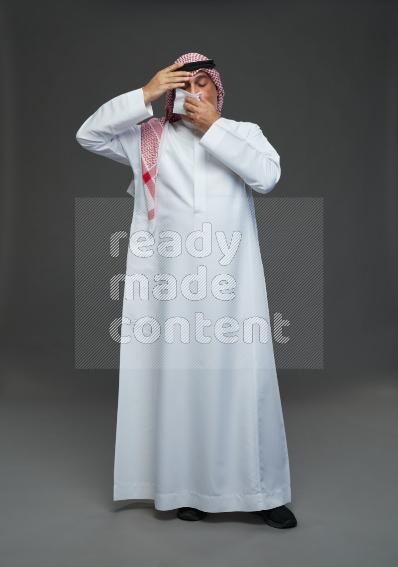Saudi man with shomag Standing feeling sick on gray background
