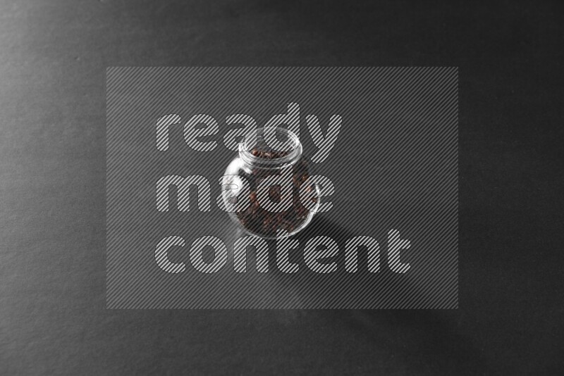 قرنفل في وعاء زجاجي علي خلفية سوداء