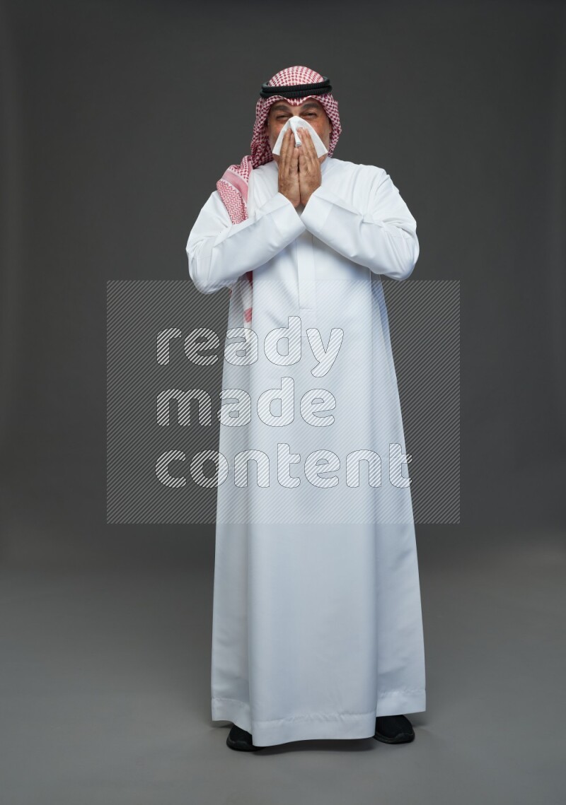 Saudi man with shomag Standing feeling sick on gray background