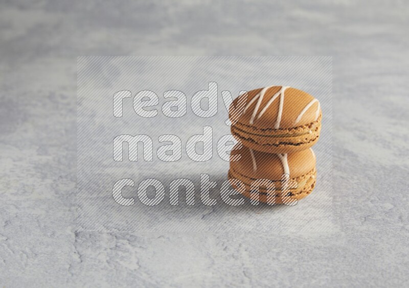 45º Shot of two Brown Irish Cream macarons  on white  marble background
