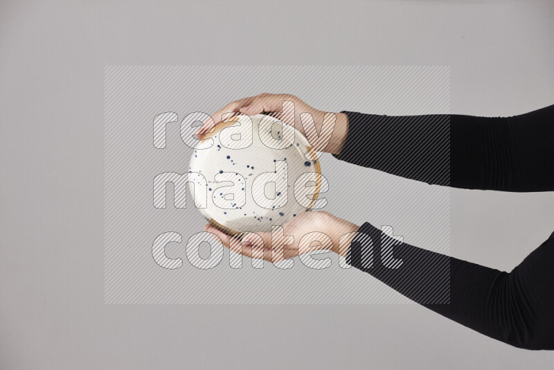 امرأة ترتدي عباءة سوداء تحمل أدوات فخارية مختلفة في أوضاع متعددة