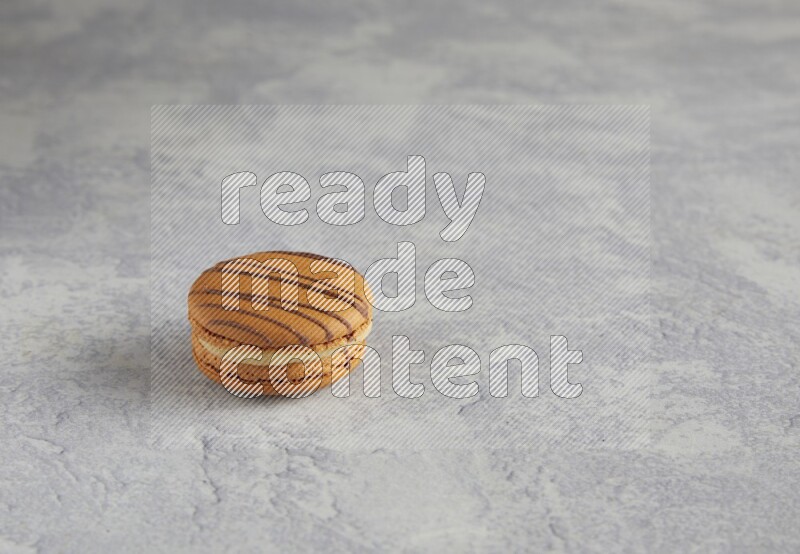 45º Shot of light brown  Almond Cream macaron on white  marble background