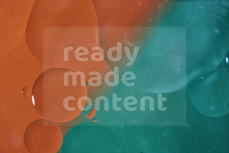 لقطات مقربة لفقاعات من الزيت على سطح الماء باللون الأخضر والبرتقالي