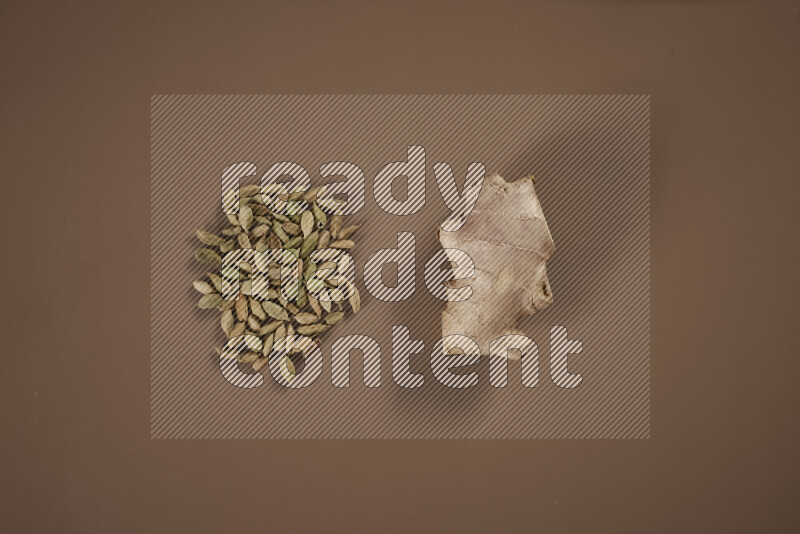 بهارات كاملة متنوعة تتضمن زنجبيل طازج ومجفف، أعواد قرفة، هيل، أصابع كركم، قرنفل، يانسون نجمي على خلفية بيج