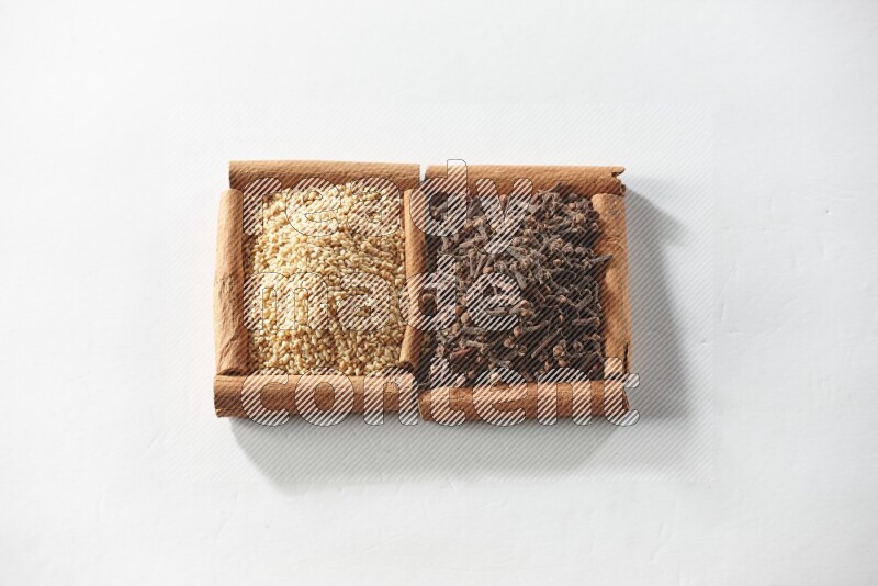 2 squares of cinnamon sticks full of cloves and sesame on white flooring