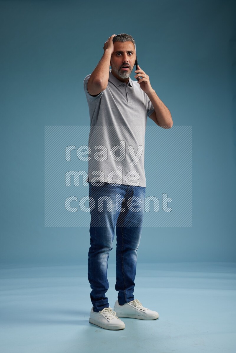 Man Standing talking on phone on blue background