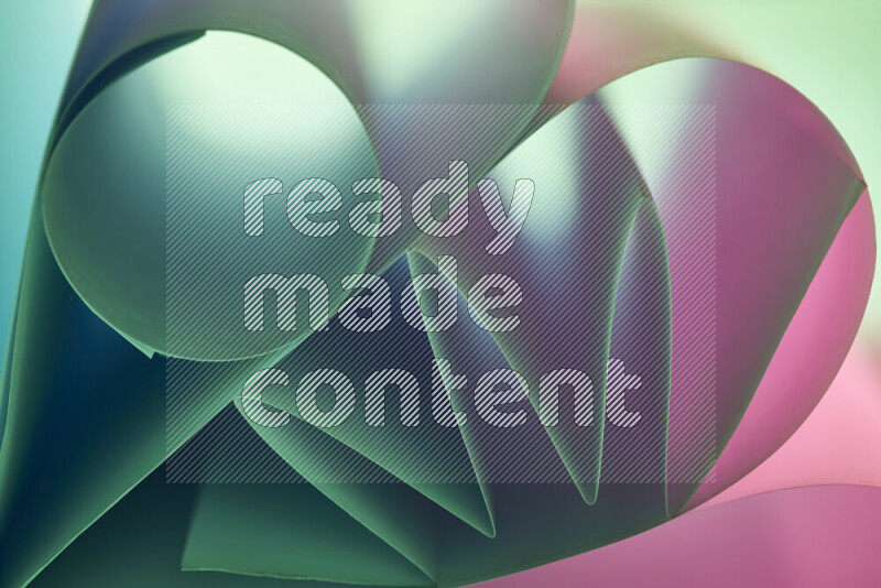 عرض فني لطيات الورق تخلق مزيج من الأشكال الهندسية، مضاءة بإضاءة ناعمة بدرجات اللون الأخضر والوردي