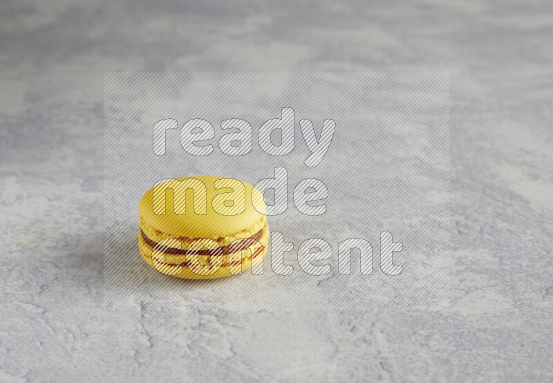 45º Shot of Yellow Lemon macaron on white  marble background