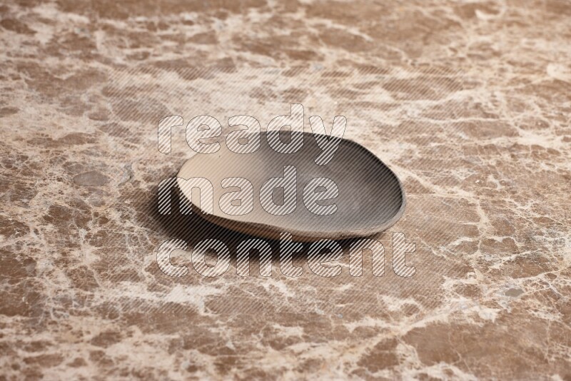 A multicolored pottery plate on beige marble background
