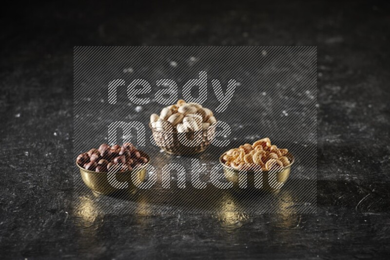 مكسرات في وعاء معدني علي خلفية سوداء