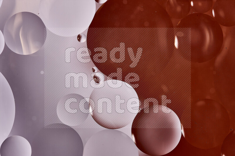 Close-ups of abstract oil bubbles on water surface in shades of white and orange