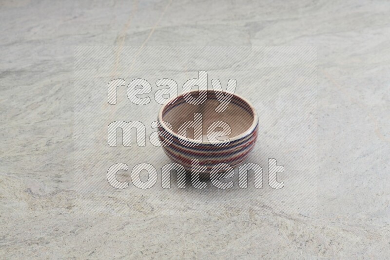 A multicolored pottery bowl on grey marble background