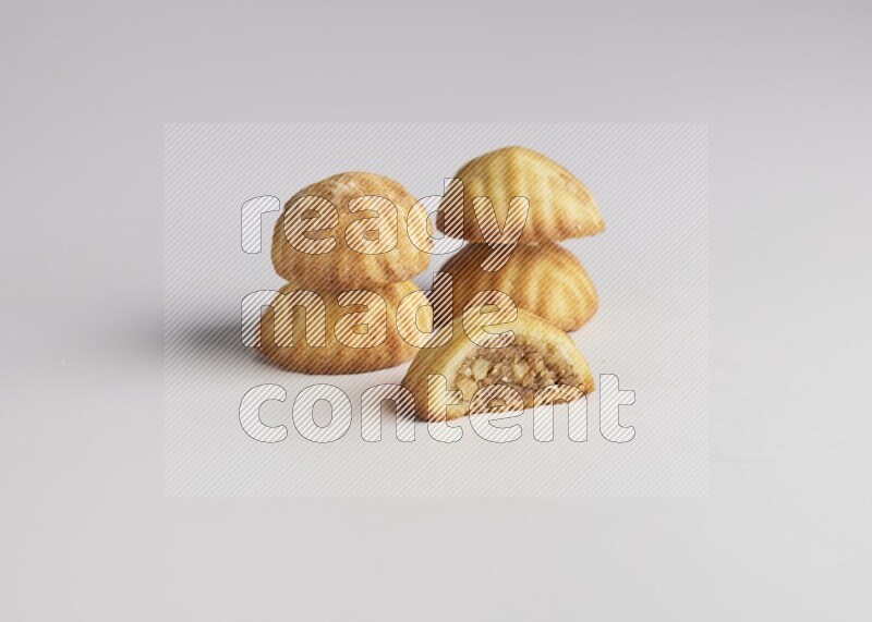 Five Pieces of Maamoul filled with walnut paste  one of them is cut with direct on white background