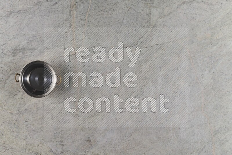 A small copper pot on grey marble background