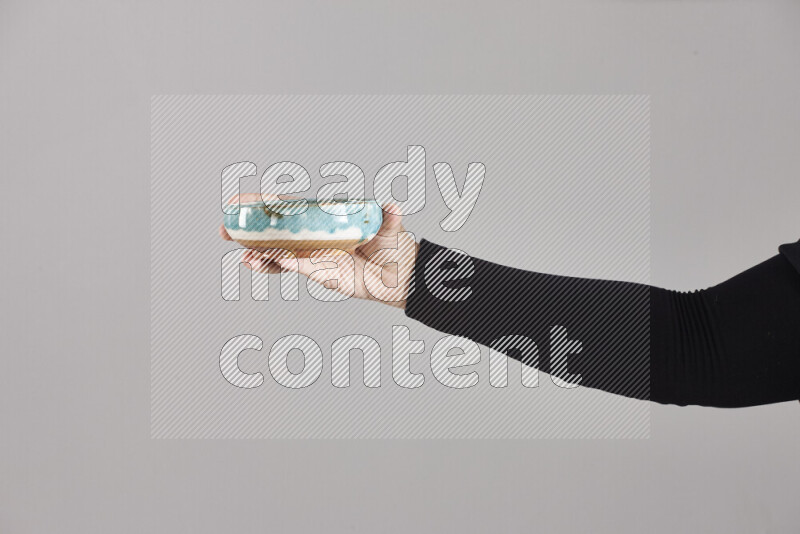 امرأة ترتدي عباءة سوداء تحمل أدوات فخارية مختلفة في أوضاع متعددة